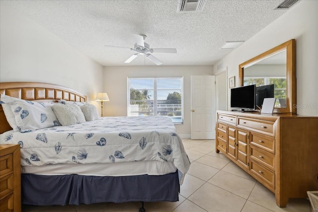 bedroom with ceiling fan, light tile floors, and a textured ceiling