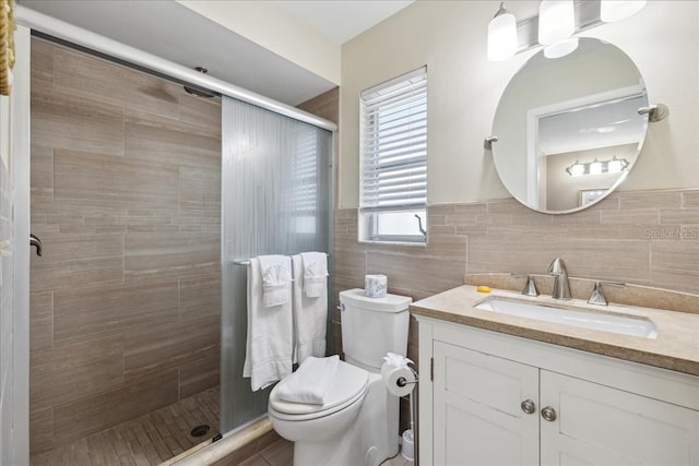 bathroom featuring vanity, backsplash, tile walls, a shower with door, and toilet