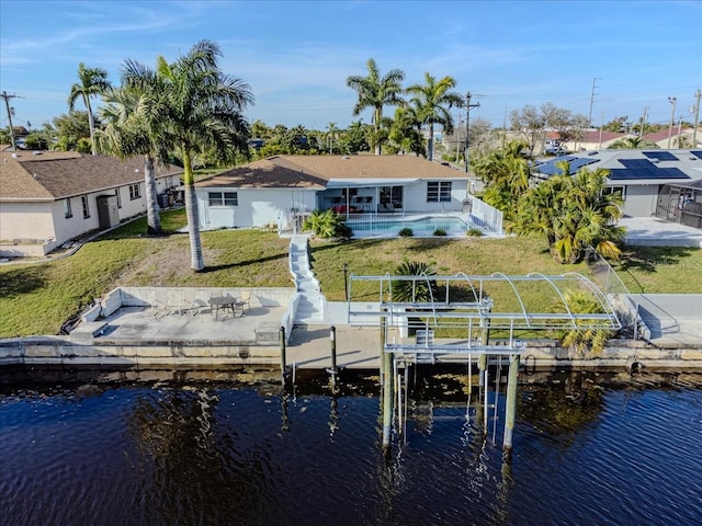 dock area with a lawn, a patio, and a water view