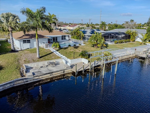 view of dock with a yard, glass enclosure, a patio, and a water view