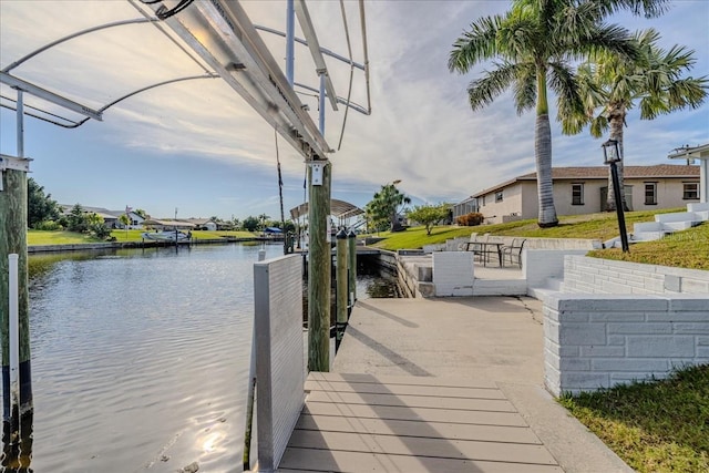 dock area with a water view and a yard