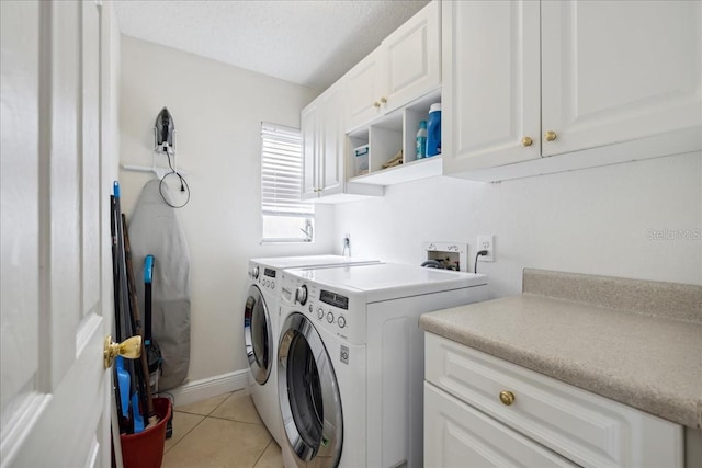 laundry area with washer hookup, washing machine and dryer, light tile floors, and cabinets