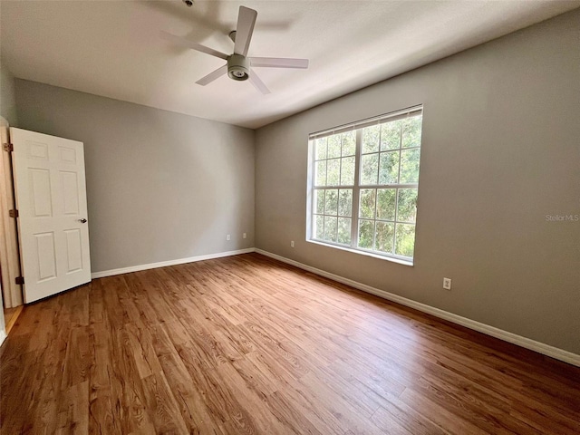 empty room with hardwood / wood-style floors and ceiling fan