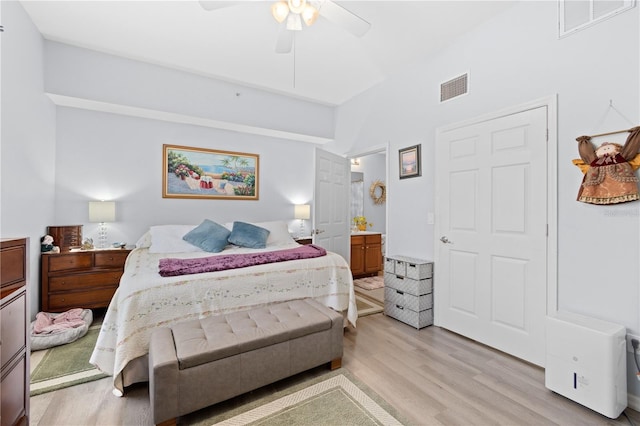 bedroom with connected bathroom, ceiling fan, and light hardwood / wood-style flooring