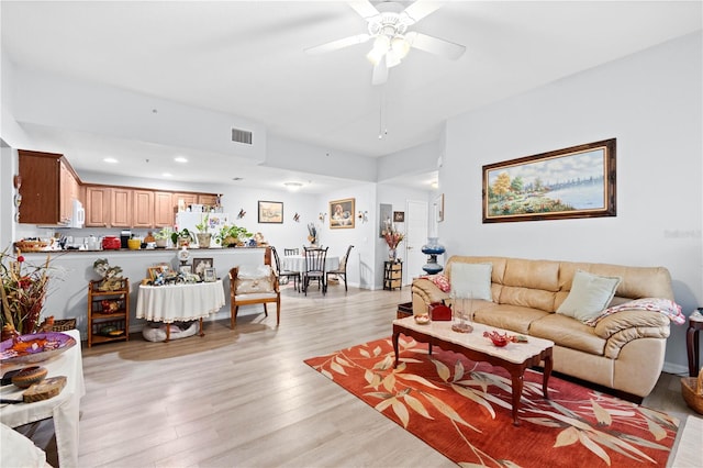 living room featuring ceiling fan and light hardwood / wood-style flooring