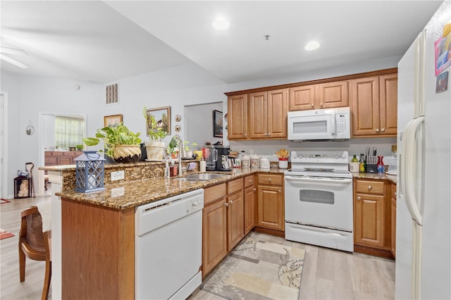 kitchen featuring kitchen peninsula, ceiling fan, white appliances, light hardwood / wood-style floors, and light stone counters