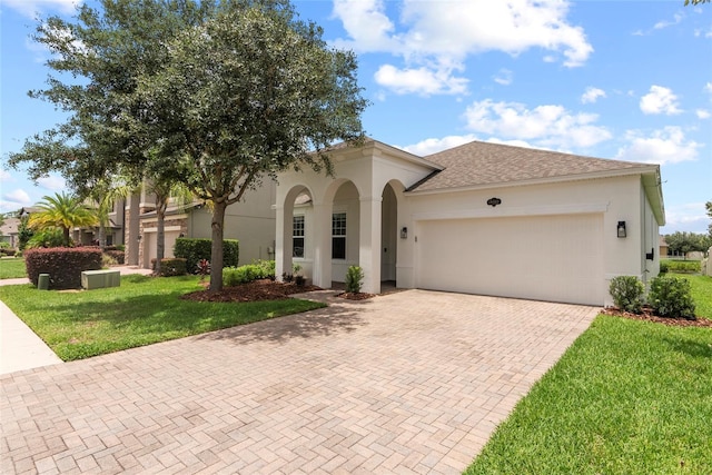 mediterranean / spanish-style home featuring a garage and a front lawn