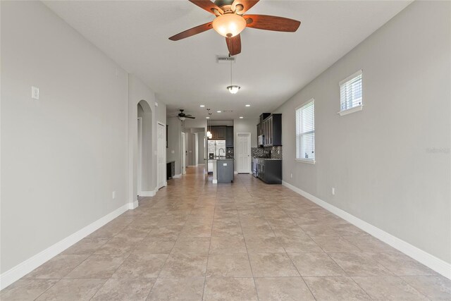 unfurnished living room with ceiling fan and light tile patterned flooring