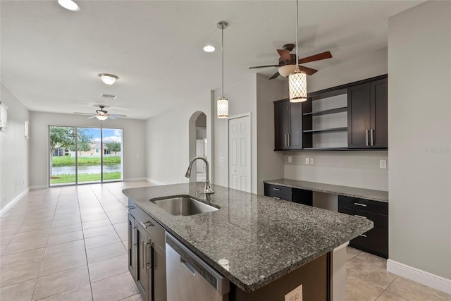 kitchen with dark brown cabinets, sink, a center island with sink, dark stone countertops, and dishwasher