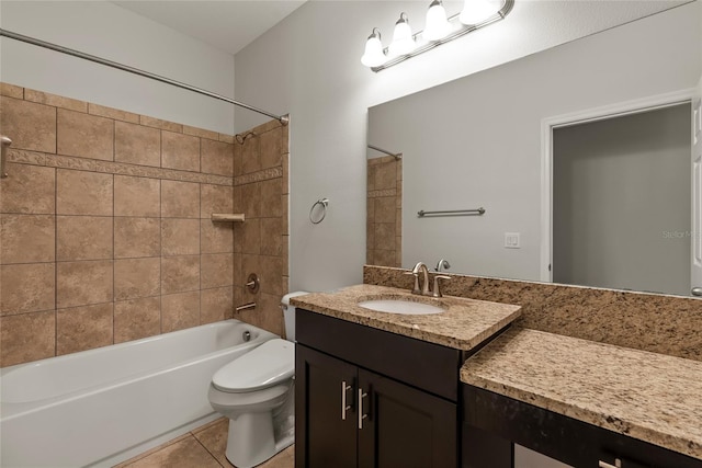 full bathroom featuring tile patterned flooring, vanity, toilet, and tiled shower / bath combo