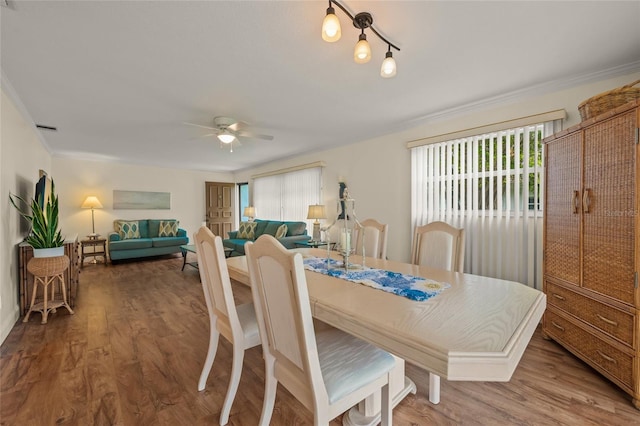 dining space with ceiling fan, a wealth of natural light, ornamental molding, and wood-type flooring