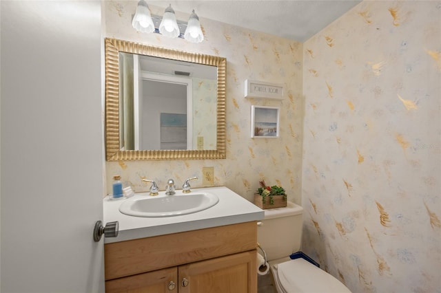 bathroom with a textured ceiling, toilet, and vanity