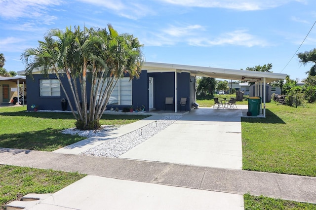 view of front of property with a carport and a front lawn