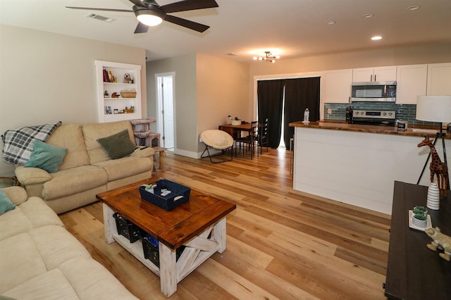 living room with ceiling fan and light hardwood / wood-style flooring