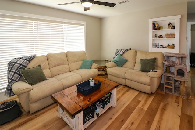 living room with light hardwood / wood-style floors and ceiling fan