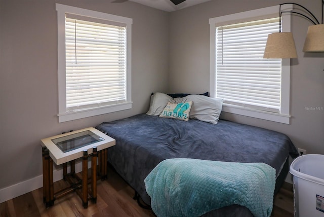 bedroom with dark hardwood / wood-style flooring and multiple windows