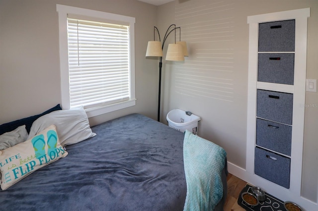 bedroom with dark hardwood / wood-style flooring and multiple windows