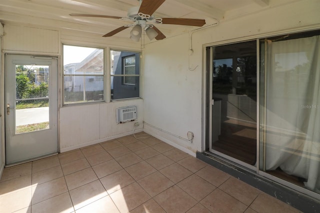 unfurnished sunroom with plenty of natural light, ceiling fan, a wall mounted air conditioner, and beamed ceiling