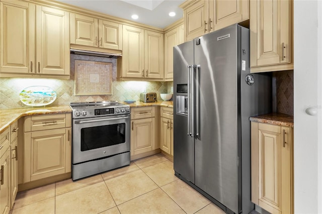 kitchen featuring backsplash, light tile floors, appliances with stainless steel finishes, and light stone counters