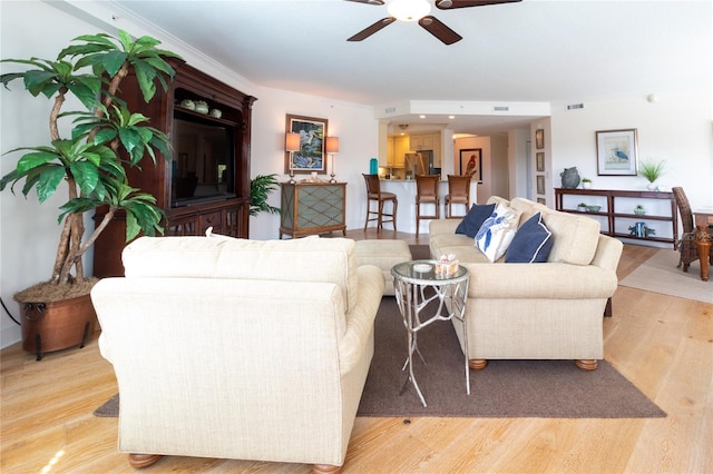 living room with light hardwood / wood-style floors and ceiling fan