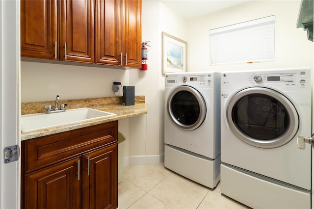 laundry room with light tile floors, cabinets, independent washer and dryer, and sink