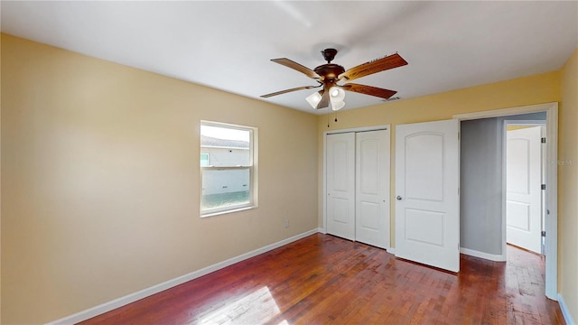 unfurnished bedroom with ceiling fan and dark wood-type flooring