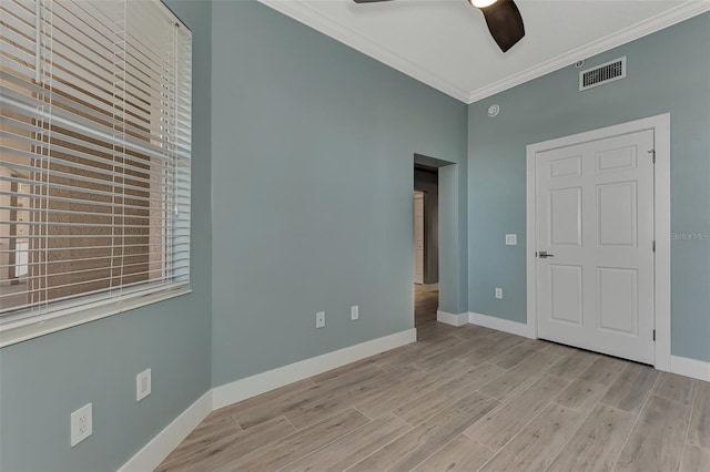 unfurnished bedroom featuring light hardwood / wood-style floors, ceiling fan, and crown molding