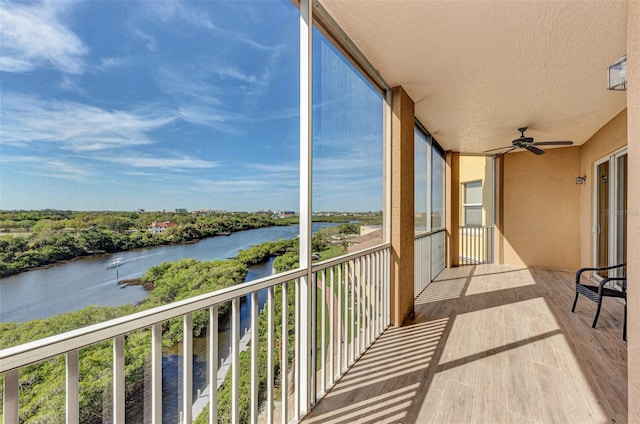 balcony with a water view and ceiling fan