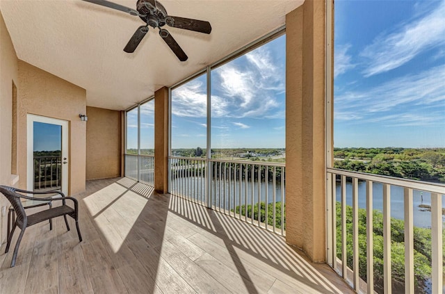 balcony featuring a water view and ceiling fan