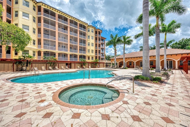 view of swimming pool featuring a community hot tub and a patio