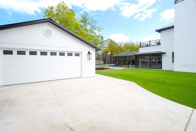 garage featuring a trampoline and a yard