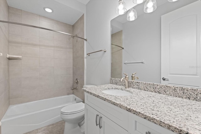 full bathroom featuring tile patterned flooring, vanity, toilet, and tiled shower / bath