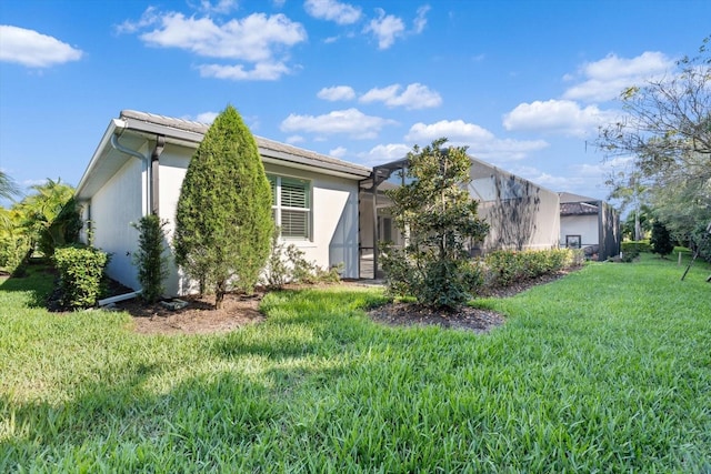 back of property with a yard and glass enclosure