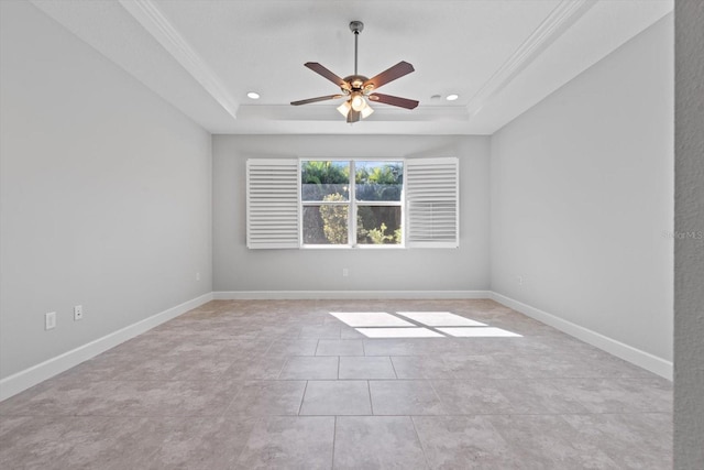 empty room with a raised ceiling, crown molding, light tile patterned floors, and ceiling fan