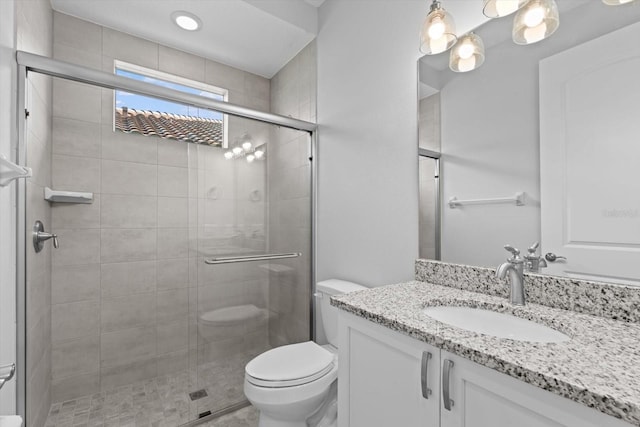 bathroom with walk in shower, vanity, and toilet