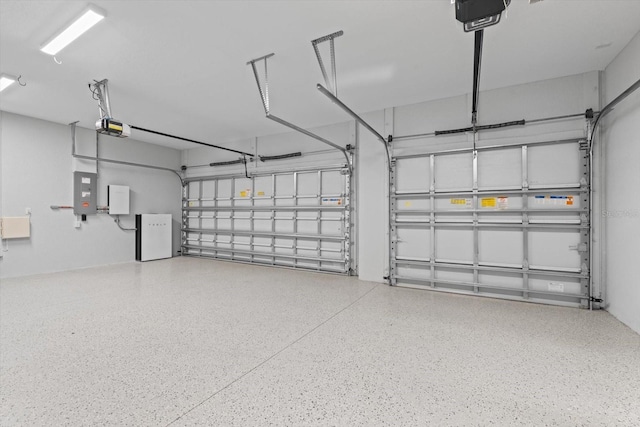 garage with electric panel and a garage door opener