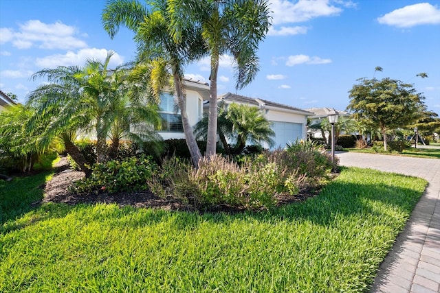 view of side of home with a lawn and a garage