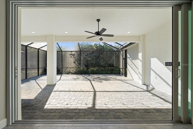 view of patio / terrace featuring ceiling fan and glass enclosure