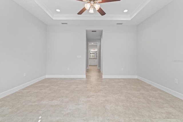 spare room featuring a tray ceiling, ceiling fan, and ornamental molding