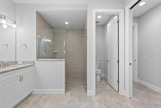 bathroom featuring an enclosed shower, vanity, and toilet