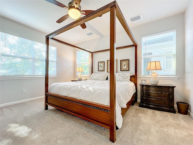 carpeted bedroom featuring multiple windows and ceiling fan