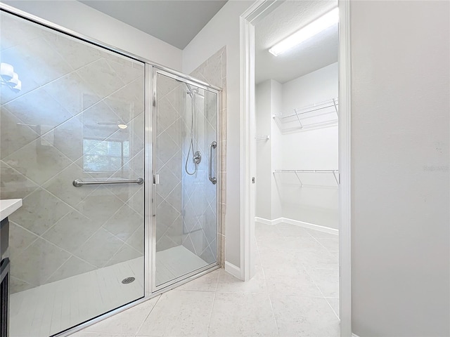 bathroom featuring tile patterned flooring, vanity, and walk in shower