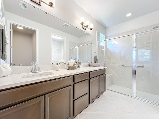 bathroom with tile patterned floors, vanity, and walk in shower