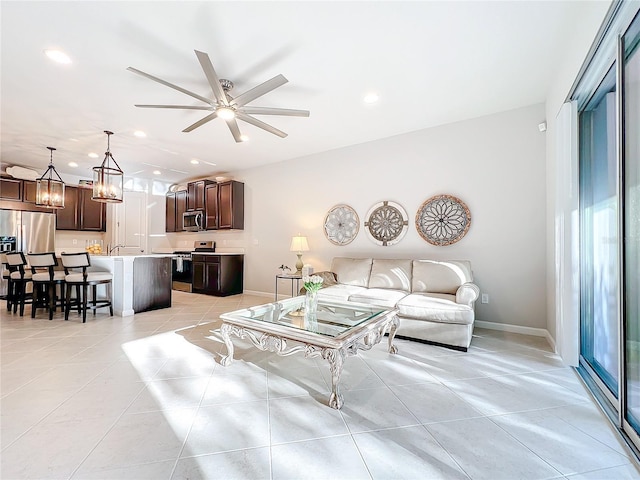 living room featuring light tile patterned flooring, recessed lighting, a ceiling fan, and baseboards