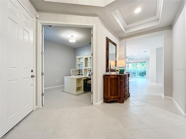 hall with a desk, baseboards, and light tile patterned floors