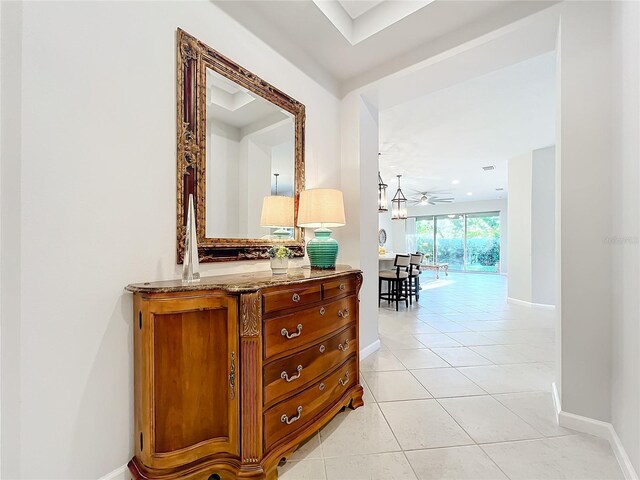 corridor with baseboards and light tile patterned flooring
