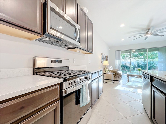 kitchen with stainless steel appliances, a ceiling fan, light tile patterned floors, light stone counters, and recessed lighting