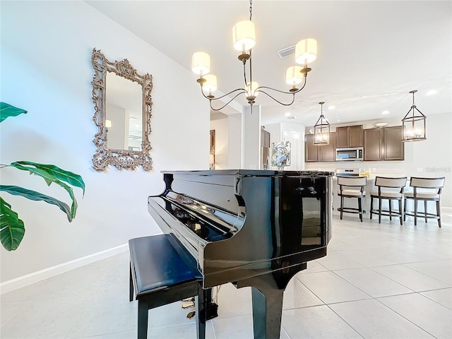 living area featuring baseboards, light tile patterned floors, and a chandelier