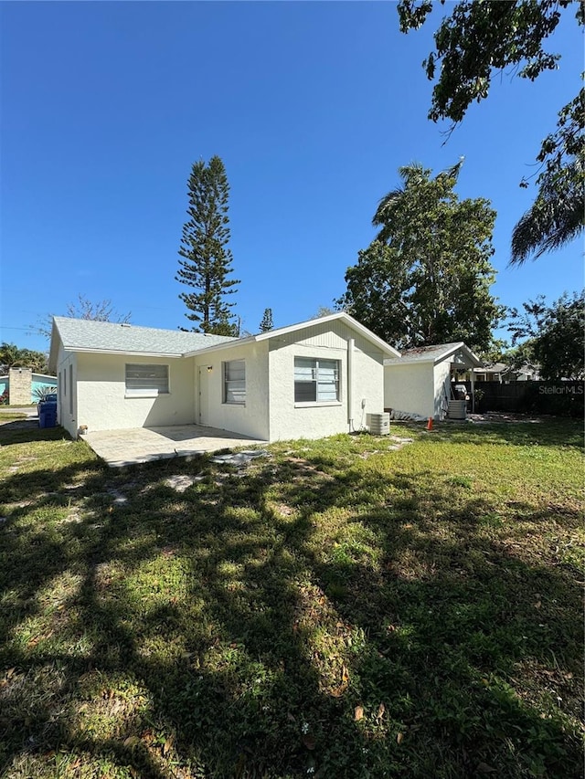 back of house with central AC unit, a patio, and a yard