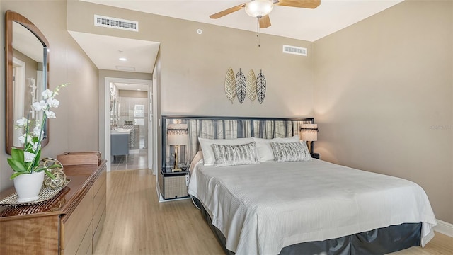 bedroom with hardwood / wood-style floors, ceiling fan, and ensuite bathroom